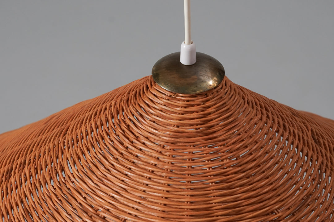 Ceiling lamp with brass counterweight. The shade is a cone-shaped basket weaved shade.