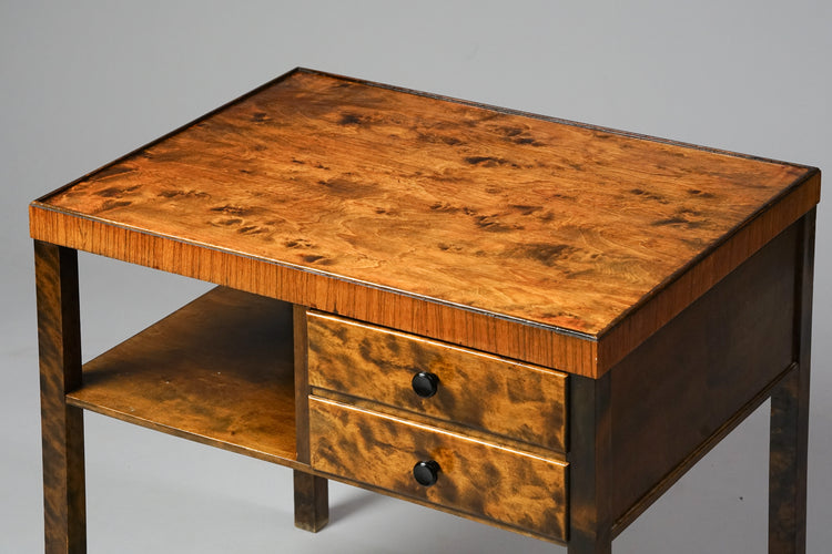 Table made of birch and flamed birch. The material has a very vivid pattern. There are two drawers and on shelf under the table.