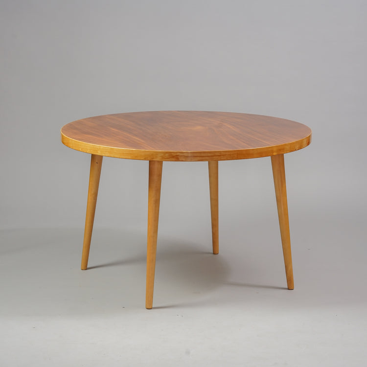 Puusta tehty pyöreä pöytä, jossa neljä jalkaa. 