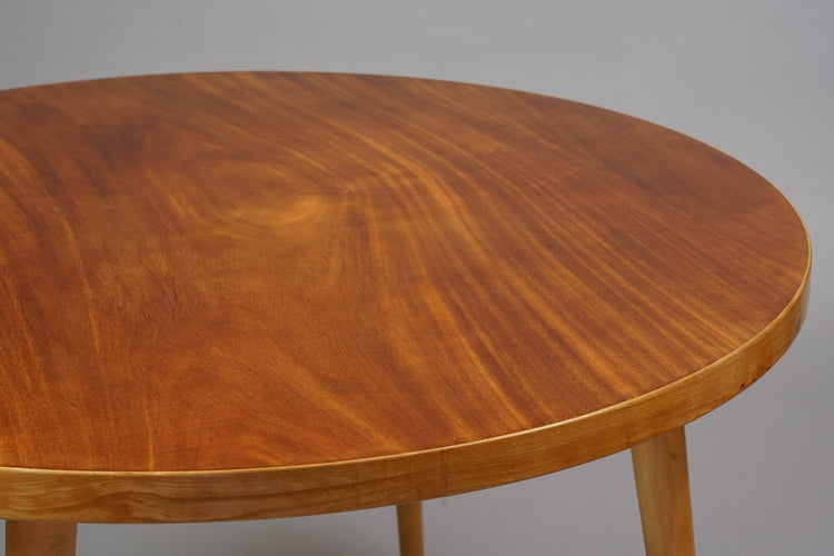 Wooden round table with four legs.
