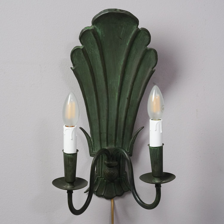 Vihreä raudasta tehty koristeellinen seinälampetti, jossa paikka kahdelle kynttilälle tai lampulle.  